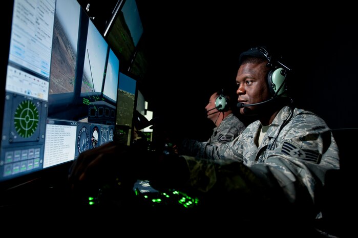 A joint terminal attack controller with the 18th Air Support Operations Squadron, Ft. Drum, N.Y., plays the role of a simulated A-10 Thunderbolt II pilot maneuvering his aircraft over a virtual battlespace in accordance with guidance transmitted to him by a JTAC Qualification Course student during a close air support training scenario inside the 6th Combat Training Squadron’s JTAC virtual training facility at Nellis Air Force Base, Nev., April 29, 2015. Using a series of integrated simulators, instructors are able to take control of various assets in the battlespace and manipulate them in ways that directly reflect the actions of a student calling shots from a simulator dome just steps away. (U.S. Air Force photo by Senior Airman Joshua Kleinholz)