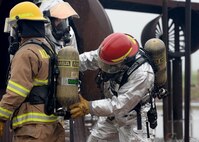 ALTUS AIR FORCE BASE, Okla. – Mike Davis, 97th Civil Engineer Squadron fire department captain, inspects a firefighter’s gear during a fire exercise at the burn pit, May 8, 2015. The fire department allowed wing leaders to put out a training aircraft fire in order to have a better understanding of the procedures followed to successfully extinguish the flames. (U.S. Air Force photo by Senior Airman Franklin R. Ramos/Released)