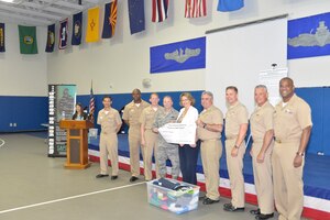 Joint Base Charleston senior leadership presents a $2,000 check and donated clothes to Kathy Gill-Hopple of the Medical University of South Carolina Sexual Assault Nurse Examiner Department during the Sexual Assault Prevention and Response Program Appreciation Luncheon April 30, 2015 at Joint Base Charleston – Weapons Station, S.C. (U.S. Air Force photo/Seamus O’Boyle)