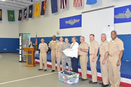Joint Base Charleston senior leadership presents a $2,000 check and donated clothes to Kathy Gill-Hopple of the Medical University of South Carolina Sexual Assault Nurse Examiner Department during the Sexual Assault Prevention and Response Program Appreciation Luncheon April 30, 2015 at Joint Base Charleston – Weapons Station, S.C. (U.S. Air Force photo/Seamus O’Boyle)