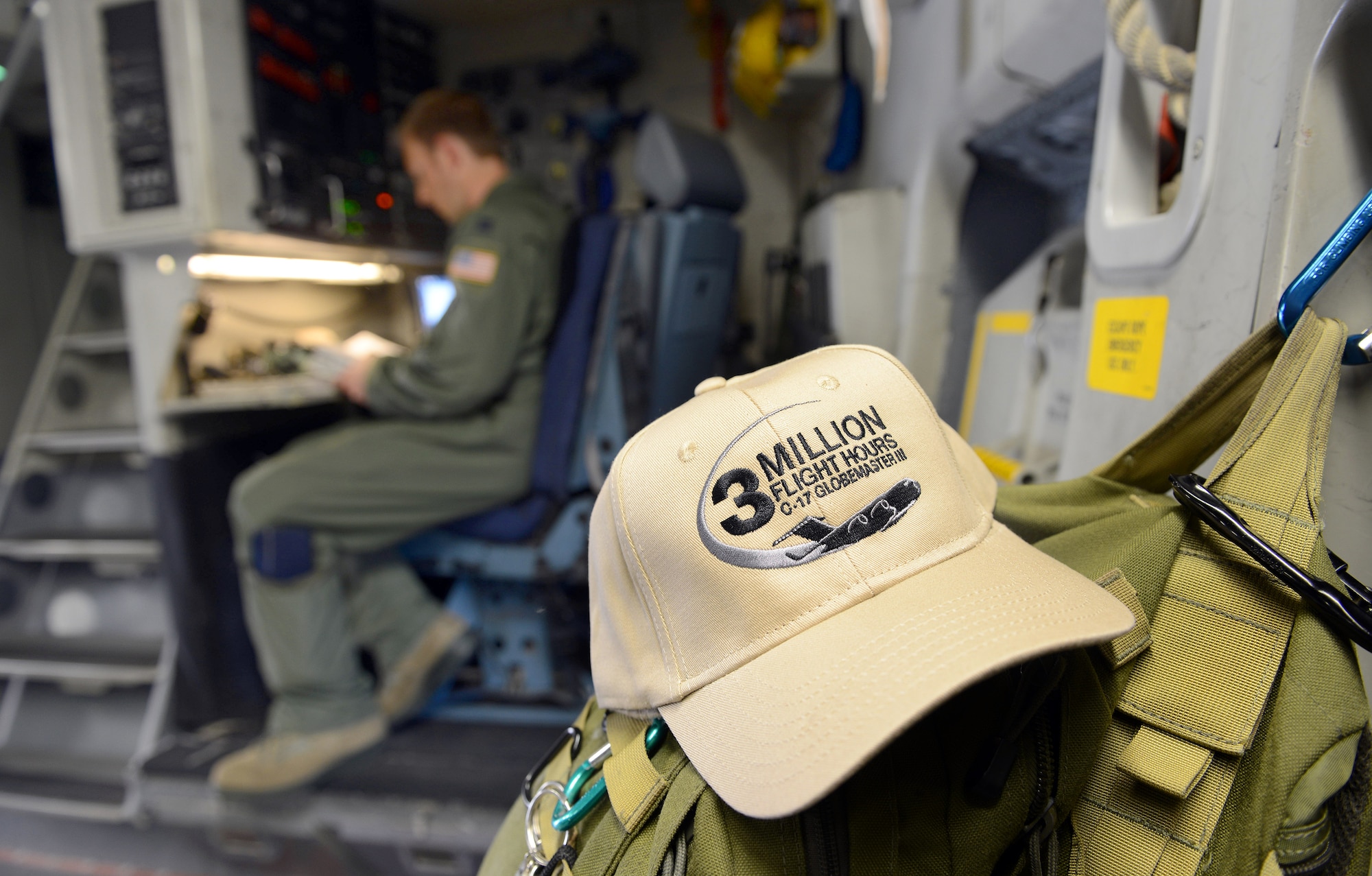 Captain Timothy Birt, 437th Airlift Wing, completes preflight checklists prior to the C-17’s departure to Joint Base Charleston S.C. The hat in the foreground was in recognition of the 3 millionth flying hour for the airframe. (U.S. Air Force photo by Tommie Horton)