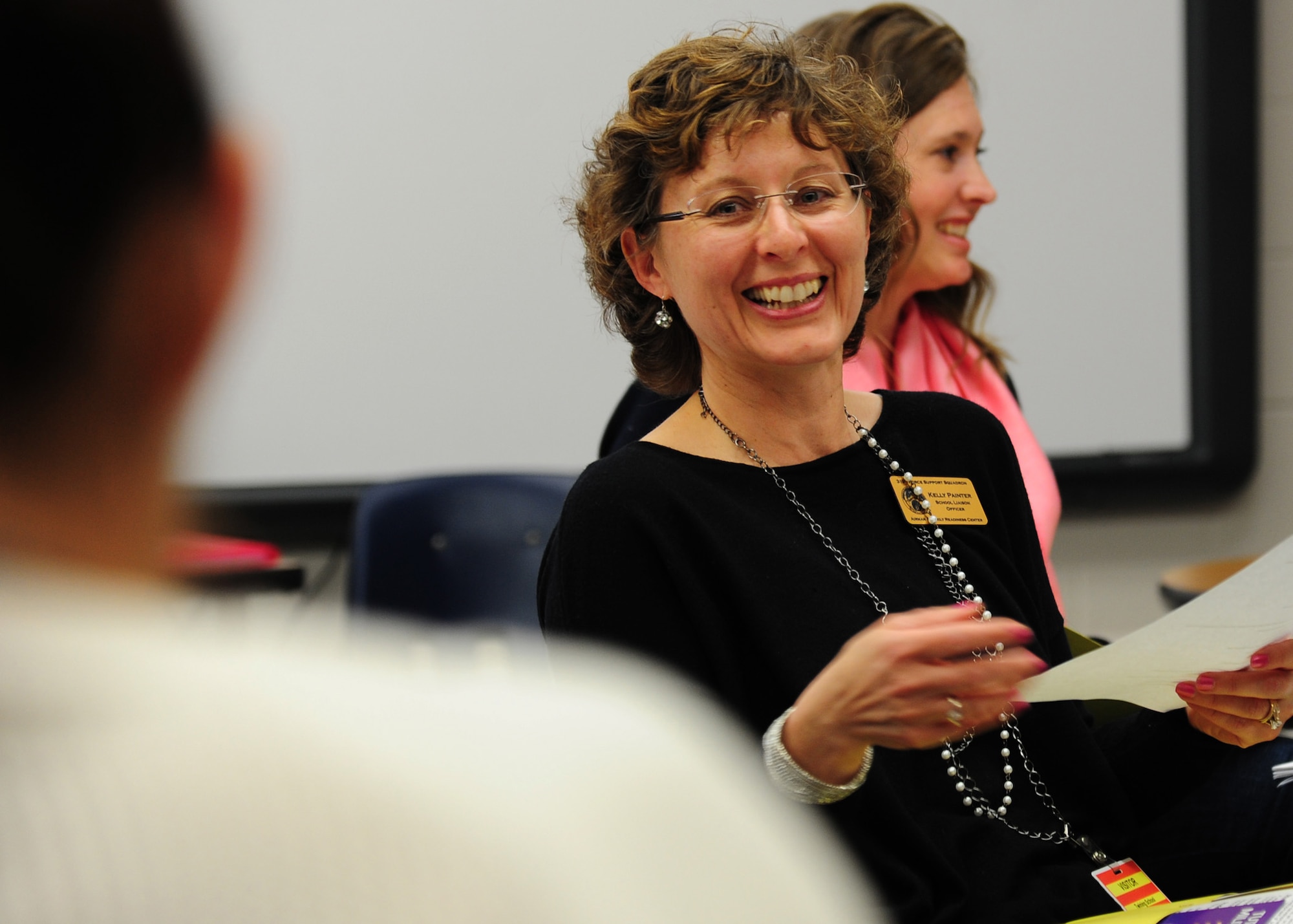 Kelly Painter, School Liaison Officer, laughs during a military parents meeting May 7, 2015 on Grand Forks Air Force Base, N.D. The School Liaison Office hosted a student school portfolio class to highlight the importance of keeping a school portfolio for a military child throughout their school career. (U.S. Air Force photo by Airman 1st Class Ryan Sparks/released)