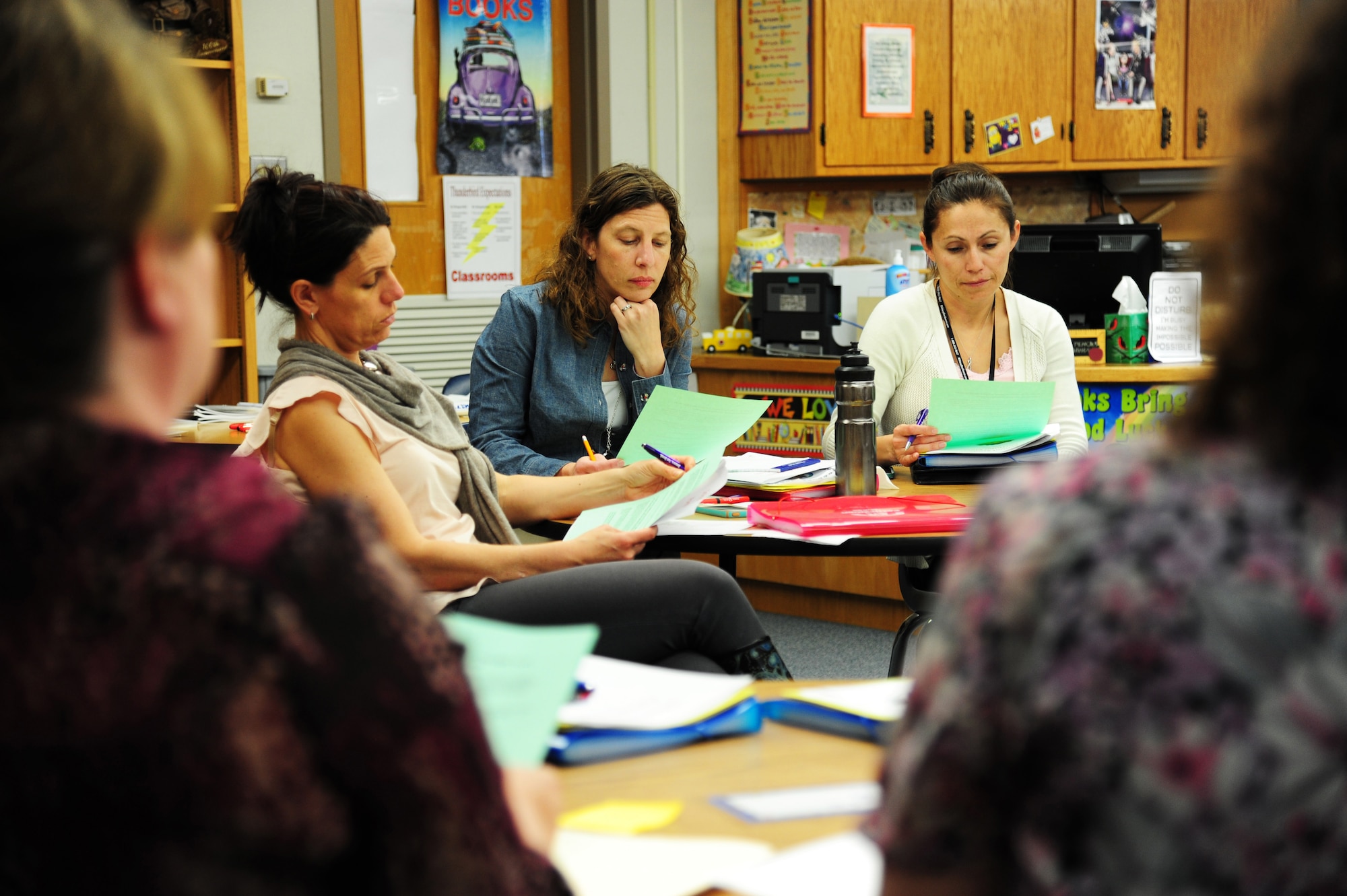 Mary Cook, left, Laura Lininger, middle, and Esmeralda Salcedo listen to a group of speakers from Twining Elementary-Middle School May 7, 2015 on Grand Forks Air Force Base, N.D. The School Liaison Office hosted a student school portfolio class to highlight the importance of keeping a school portfolio for a military child throughout their school career. (U.S. Air Force photo by Airman 1st Class Ryan Sparks/released)