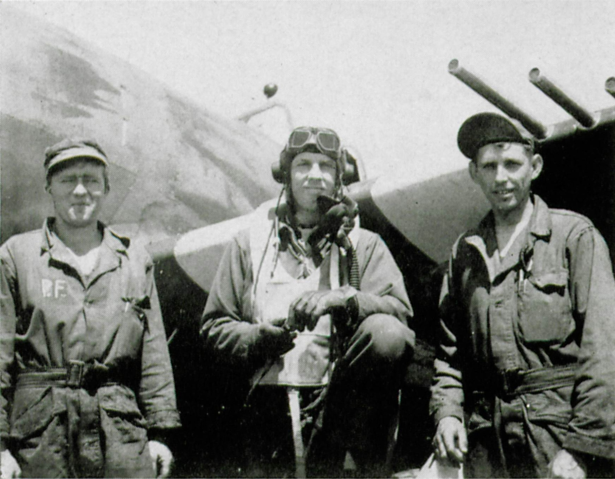 Group Commander Col. Bingham T. Kleine was the wartime commander of the 371st Fighter Group.  He is shown here in between two members of his ground crew, likely men from the 404th Fighter Squadron.  The initial P.F. on the overall on the man at left suggest possibly Sgt. Percy M. Freer of that squadron.  This picture may have been taken on D-Day, just prior to the group’s first mission that day, with the famous black/white recognition stripes visible on the wing behind them.  (The Story of the 371st Fighter Group in the E.T.O.)