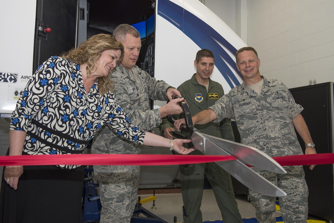 U.S. Air Force Col. Samuel Milam, Air Education and Training Command eputy director of intelligence operations and nuclear intelligence for flying training, (left), cuts the ribbon for AETC’s first Spatial Disorientation Trainer beside Valerie Dahlem, from the Air Force Life Cycle Management Center, (far left), Col. Gregory Keeton, 80th Flying Training Wing commander, (right), and Col. Gregory DeWolf, 82nd Medical Group commander, (far right), at Sheppard Air Force Base May 7, 2015. The trainer simulates different air sicknesses that pilots may experience when flying. Instructors have the ability to walk student pilots through these experiences, teaching them how to combat the disorientation effectively. (U.S. Air Force photo by Senior Airman Kyle Gese/Released)