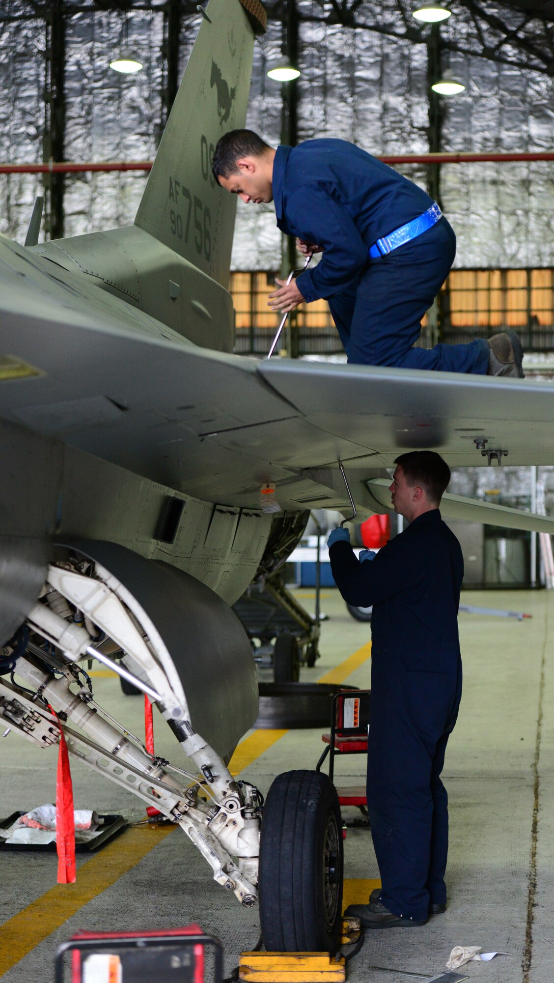 One up; one down Crew Chiefs assigned to the 51st Maintenance Squadron Phase Docks replace wing paneling on an F-16 Fighter jet at Osan Air Base, Republic of Korea, 16 April 2015. Crew Chiefs work around the clock at depaneling and inspecting all standard carded items such as the wings, landing gear and fuselage as well as performing preventive maintenance on the jet as a whole.  (USAF photo by Staff Sgt. Amber Grimm)