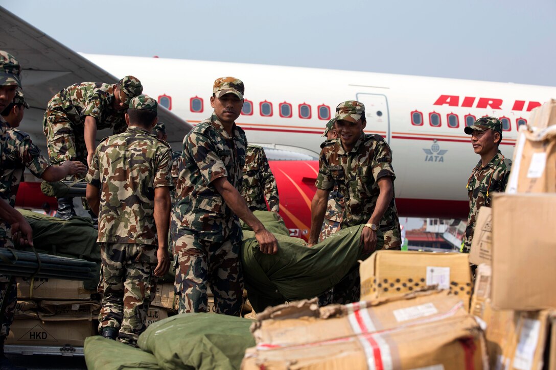 Nepalese service members offload pallets of humanitarian aid supplies during Joint Task Force 505 humanitarian assistance and disaster relief at Tribhuvan International Airport, Kathmandu, Nepal, May 7, 2015.