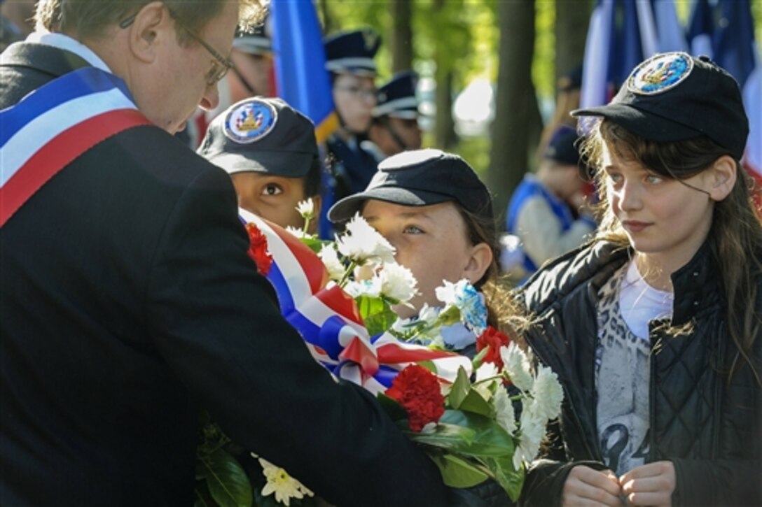 French residents gather with French troops and veterans and U.S. troops in the village of Schoeneck, France, May 8, 2015, during the 70th anniversary of the Victory in Europe Day. The parade and ceremony commemorated the day Germany surrendered to allied forces in 1945, marking the end of World II in Europe. 