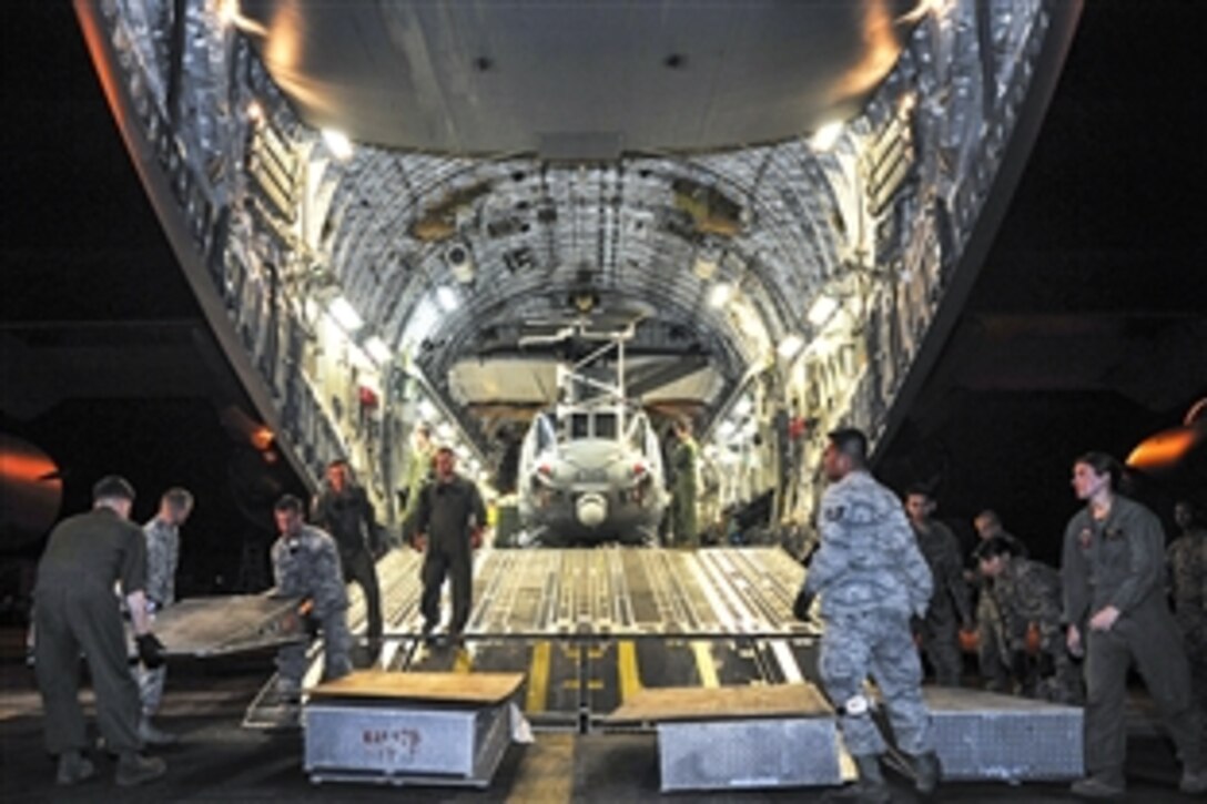 Airmen and Marines unload a Huey helicopter from a C-17 Globemaster III at Tribhuvan International Airport in Nepal, May 5, 2015. U.S. Pacific Command is helping Nepal and its people recover following a recent magnitude-7.8 earthquake.