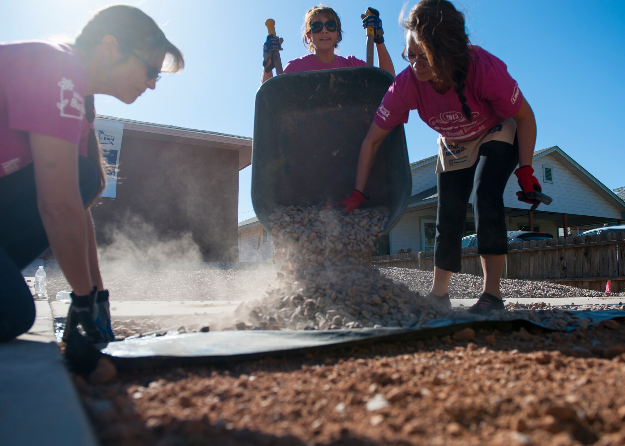 Volunteers lay gravel outside of a Habitat for Humanity construction site in downtown Alamogordo, N.M., May 9, 2015. The volunteers were participating in National Women Build Week, an annual event hosted by Habitat for Humanity where multiple volunteers devote their time to come together to help the members of the community who are less fortunate by providing them with shelter above their heads. (U.S. Air Force photo by Senior Airman Leah Ferrante/released)