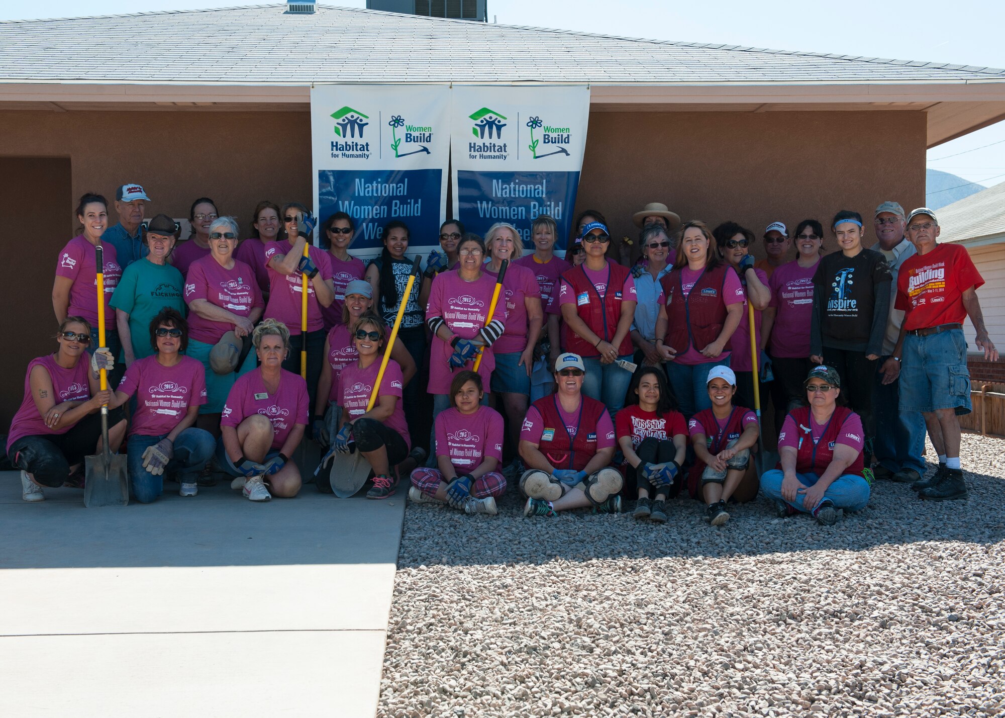 Volunteers and the future homeowners pose for a group photo during National Women Build Week hosted by Habitat for Humanity in downtown Alamogordo, N.M., May 9, 2015. This year, members of Holloman Air Force Base volunteered their time with Habitat for Humanity for a women empowering event to give one of the best gifts of all, a new home for a member of our local family. This event also teaches women different skillsets while getting them out to volunteer in the community. (U.S. Air Force photo by Senior Airman Leah Ferrante/released)