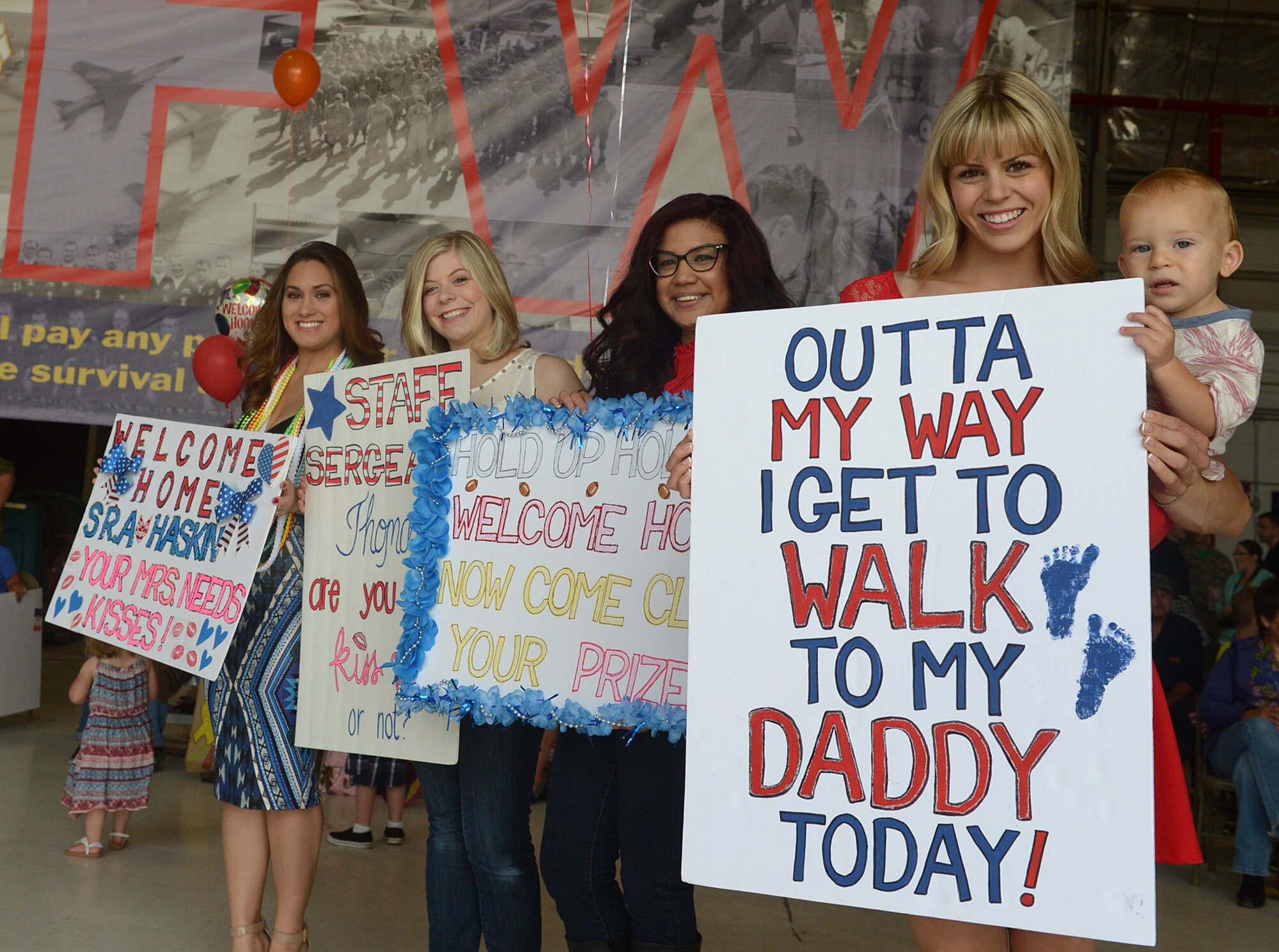 Signs are never in short supply as spouses wait to greet Hill AFB Airmen coming home from a six-month deployment in Afghanistan. Pilots, maintenance, and operations support personnel from the 388th Fighter Wing and 419th Fighter wing were assigned to the 455th Expeditionary Operations Group alongside Airmen from Hill's active-duty 388th Fighter Wing. The deployment is part of Operation Freedom's Sentinel, which aims to maintain security and stability in the area following Operation Enduring Freedom, which officially concluded in 2014.(U.S. Air Force/Alex R. Lloyd)