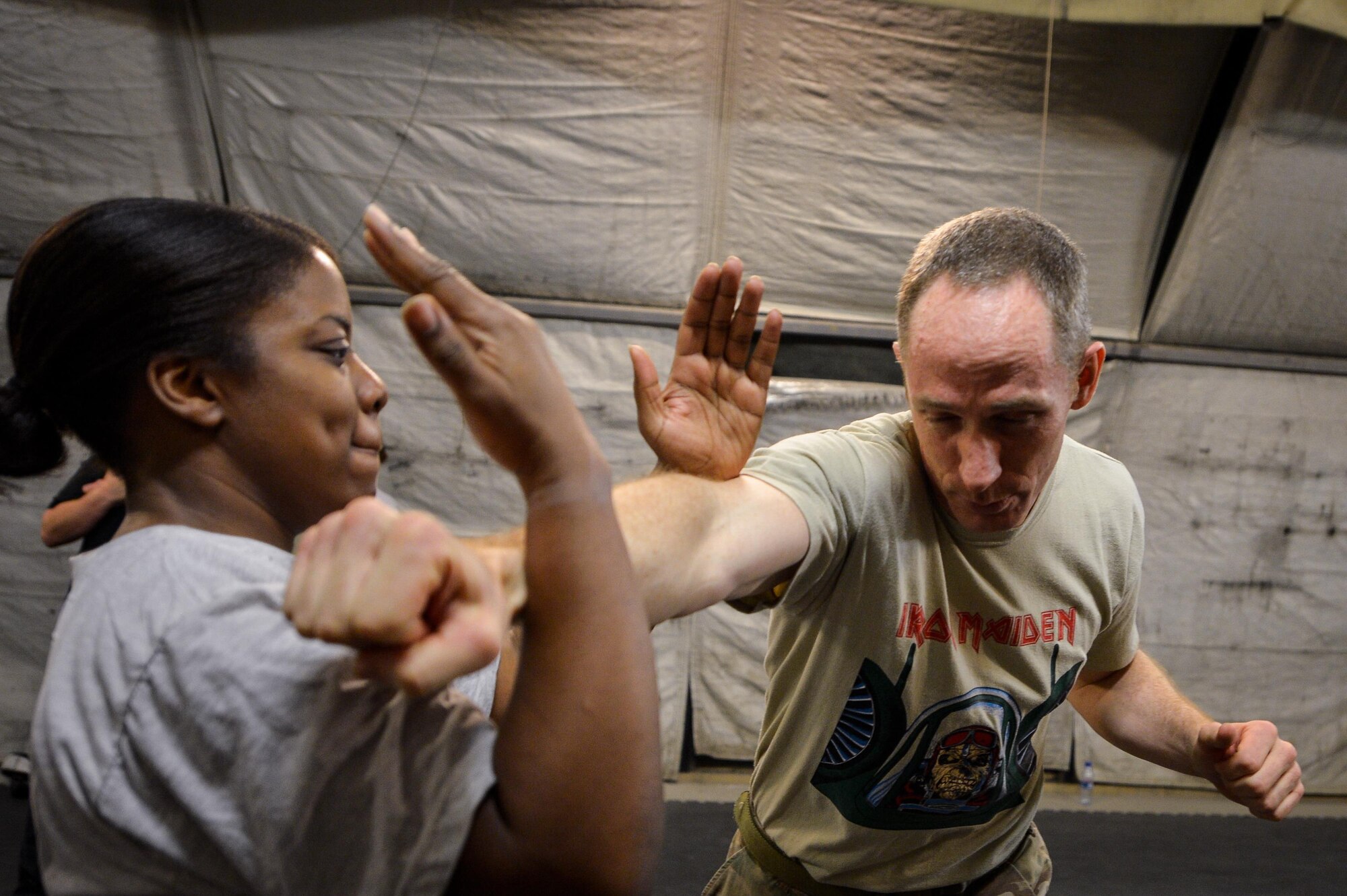 U.S. Air Force Senior Airman Tiffany Hamilton, left, 455th Expeditionary Medical Operations Squadron medical technician, and Lt. Col. Paul Cory, 817th Expeditionary Air Support Operations Squadron commander, practice Krav Maga techniques during a bi-weekly class at Bagram Airfield, Afghanistan, May 7, 2015.  The training helps Airmen better understand how to defend themselves where they live and work while in a combat environment. (U.S. Air Force photo by Tech. Sgt. Joseph Swafford/Released)