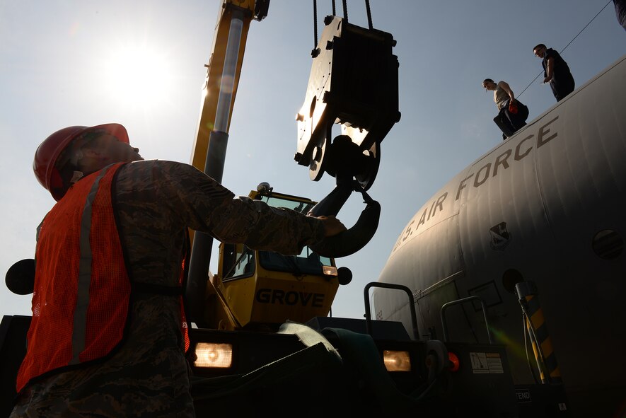 Tech. Sgt. Mike Massey, pavements and equipment NCO in charge with the 374th Civil Engineer Squadron, steadies the hook block of a crane, April 29, 2015 at Yokota Air Base, Japan. The crane lifted the engines off the wings of a C-130 Hercules for repairs. (U.S. Air Force photo by Airman 1st Class Elizabeth Baker/Released)