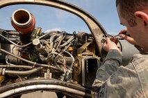 Airman 1st Class Curtis Doherty, aircraft metals technology journeyman with the 374th Maintenance Squadron, measures receptacles on a C-130 Hercules wing, April 29, 2015 at Yokota Air Base, Japan. The measurements are taken down to fractions of millimeters to check for damages. (U.S. Air Force photo by Airman 1st Class Elizabeth Baker/Released)