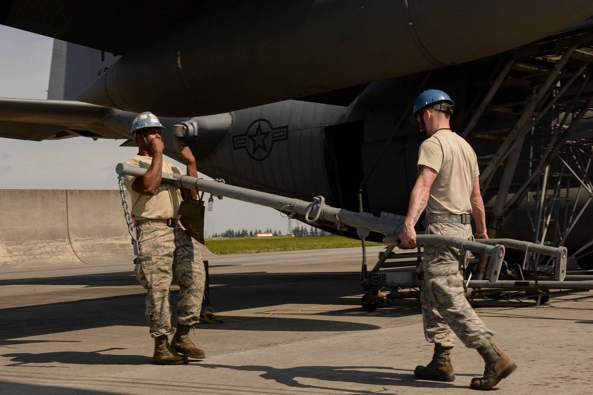 Airman 1st Class Jonathan L. Ball, left, aerospace propulsion journeyman with the 374th Aircraft Maintenance Squadron, and Staff Sgt. Dwayne Trett, aerospace propulsion craftsman with the 374th Maintenance Squadron, carry a harness, April 29, 2015 at Yokota Air Base, Japan. The harness was used to secure a crane to one of the engines of a C-130 Hercules so that the engine could be lowered to the ground for maintenance. (U.S. Air Force photo by Airman 1st Class Elizabeth Baker/Released)