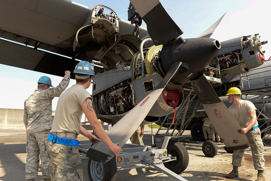 Airman 1st Class Spencer Everitt, left, and Senior Airman Kyle Wilson, right, both with the 374th Aircraft Maintenance Squadron, steady the blades of a C-130 H engine while it is secured for transportation, April 29, 2015 at Yokota Air Base, Japan. The process of removing a single engine took approximately 45 minutes to complete. (U.S. Air Force photo by Airman 1st Class Elizabeth Baker/Released)