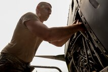 Staff Sgt. Austin Dischert, isochronal crew chief with the 374th Maintenance Squadron, loosens a component of a C-130 Hercules engine, April 29, 2015 at Yokota Air Base, Japan. The 374 MXS and the 374th Aircraft Maintenance Squadron removed all four engines from the C-130 H in one day for repairs, which is such a rare operation that none of the maintainers had performed it before. (U.S. Air Force photo by Airman 1st Class Elizabeth Baker/Released)