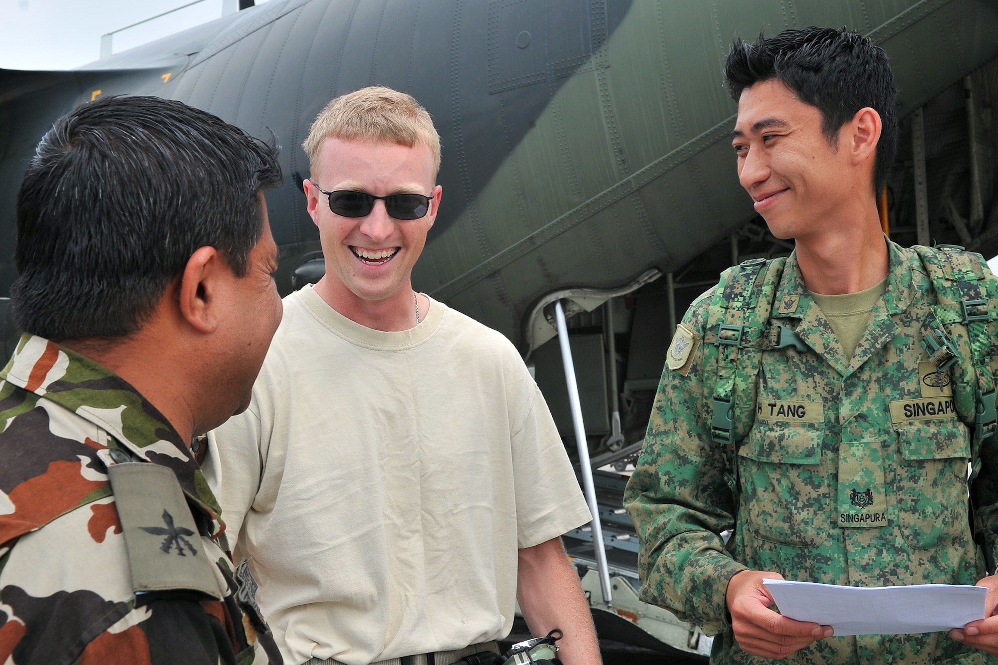 U.S. Air Force Tech. Sgt. Kenneth Kauffman, 36th Mobility Response Squadron ramp coordinator, talks with Nepalese Army and Republic of Singapore Air Force members after unloading relief supplies from an RSAF C-130 Hercules May 9, 2015, at the Tribhuvan International Airport in Kathmandu, Nepal. The Nepalese army and Airmen worked together to process 537,816 pounds of cargo in a 24-hour period from 13 aircraft delivering relief supplies after a magnitude 7.8 earthquake struck the nation April 25, 2015. (U.S. Air Force photo by Staff Sgt. Melissa B. White/Released)