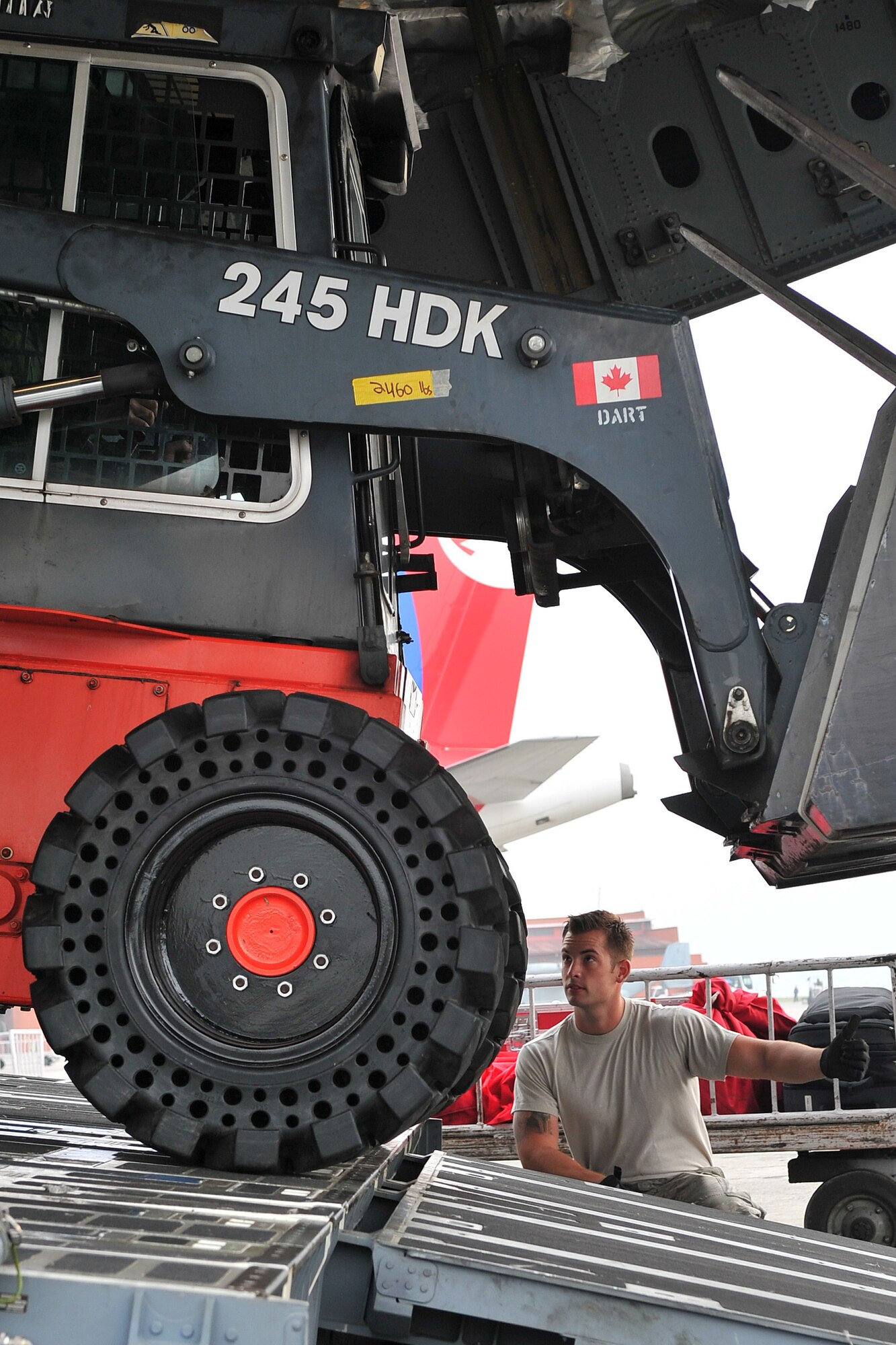 U.S. Air Force Staff Sgt. Josh Foley, 36th Mobility Response Squadron aerial port supervisor, guides a Canadian Forces member unloading equipment from their C-17 Globemaster III May 9, 2015, at the Tribhuvan International Airport in Kathmandu, Nepal. The Nepalese army and Airmen worked together to process 537,816 pounds of cargo in a 24-hour period from 13 aircraft delivering relief supplies after a magnitude 7.8 earthquake struck the nation April 25, 2015. (U.S. Air Force photo by Staff Sgt. Melissa B. White/Released)