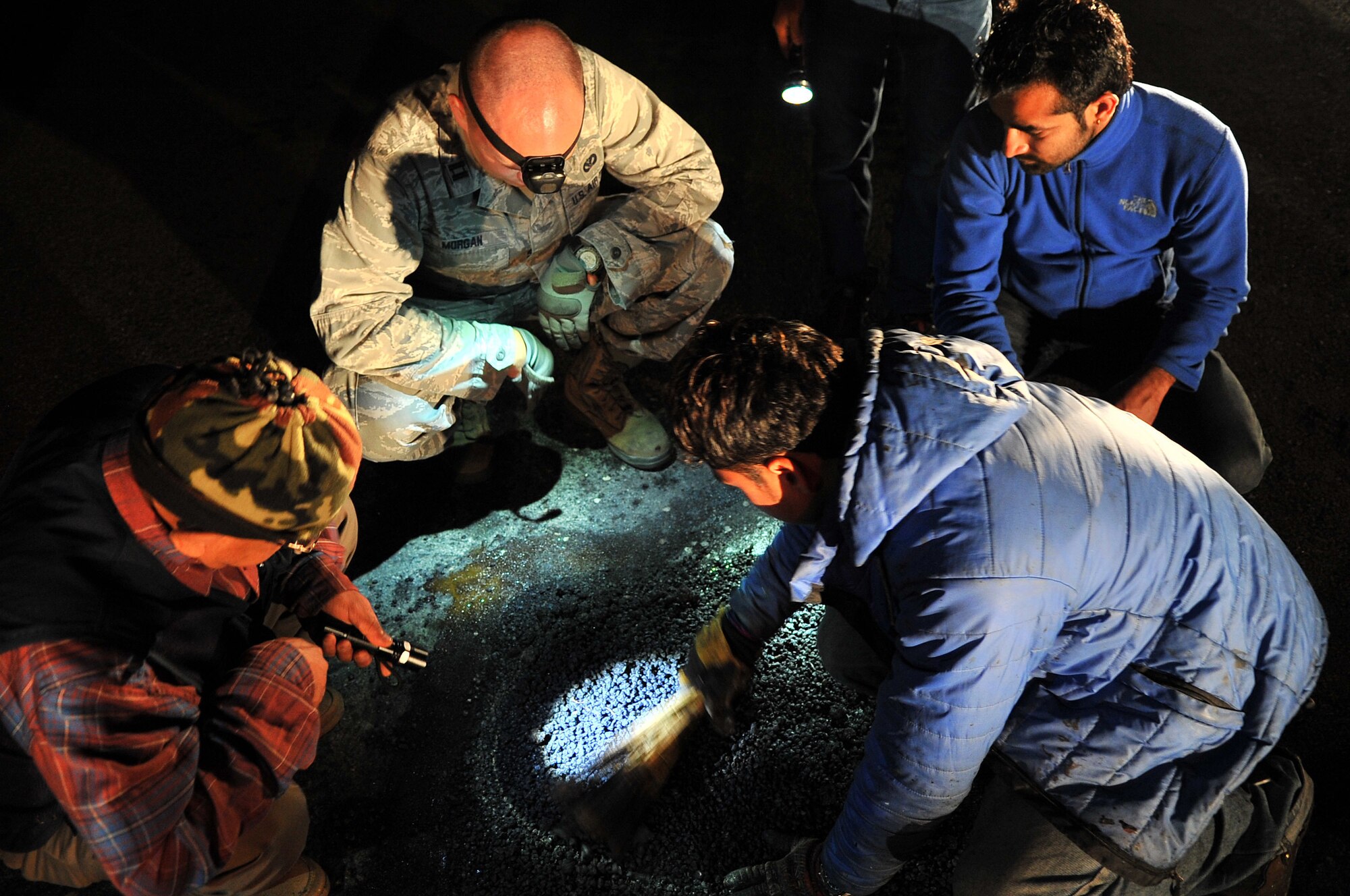 U.S. Air Force Capt. Clark Morgan, 36th Mobility Response Squadron Contingency Engineer Flight commander with Joint Task Force-505, along with Civil Aviation Authority of Nepal members work to repair the runway at the Tribhuvan International Airport in Kathmandu, Nepal, May 10, 2015. The Nepalese officials and Airmen teamed up to conduct necessary repairs to the airfield after it sustained damage following a magnitude 7.8 earthquake that struck the nation April 25, 2015. In response to the Nepal earthquake, the U.S. military sent Airmen, Marines, Soldiers and Sailors as part of JTF-505 to support the humanitarian assistance and disaster relief mission in Nepal at the direction of U.S. Agency for International Development. (U.S. Air Force photo by Staff Sgt. Melissa B. White/Released)