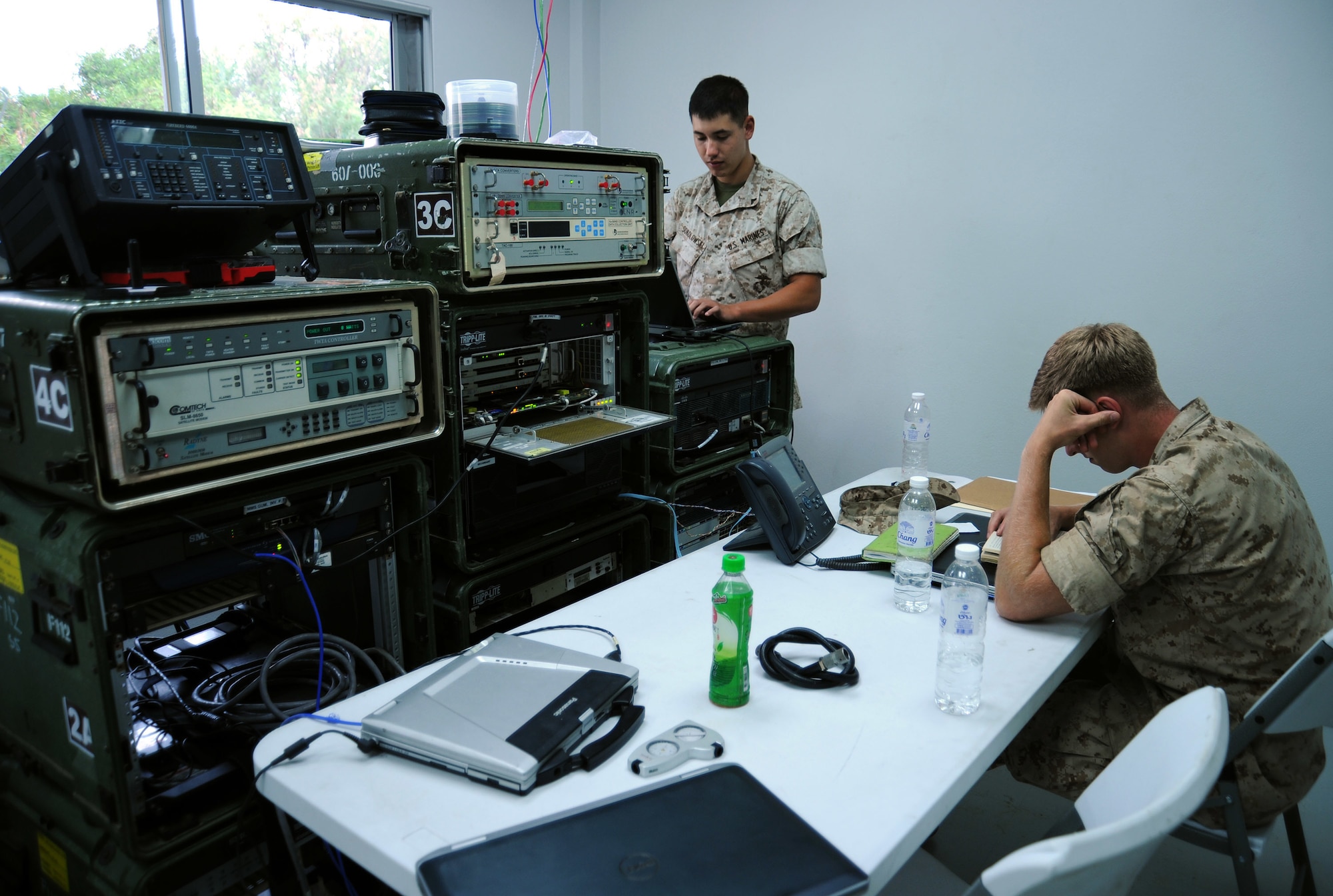 U.S. Marine Lance Corps Cpl. Alex Sokolowski and Pfc. Jennings Waddell monitor and maintain communication and satellite systems at the Joint Task Force-505 Intermediate Staging Base on Utapao Royal Thai Navy Airfield, Thailand, May 10, 2015. The joint operations center established in Utapao serves as a staging point for JTF-505 aviation assets and key planners conducting humanitarian aid and disaster relief operations in support of the 7.8 magnitude earthquake that struck Nepal, April 25, 2015. Sokolowski and Waddell are deployed to Utapao from the 7th Communication Battalion, Camp Hansen, Japan. (U.S. Air Force photo by Staff Sgt. Alexander Martinez/Released)