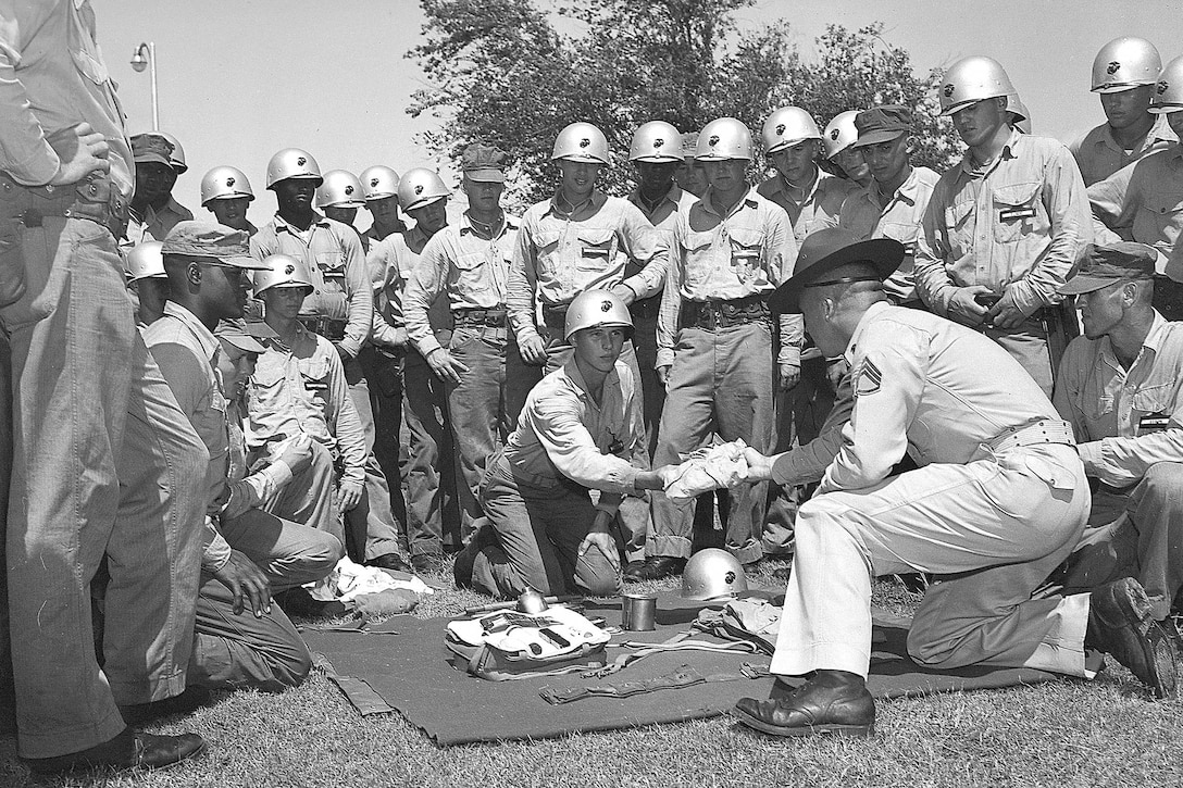 A drill instructor shows recruits different training items in this circa 1956 photo on Marine Corps Recruit Depot Parris Island, S.C. This gear was very similar to the kind they would use as Marines.