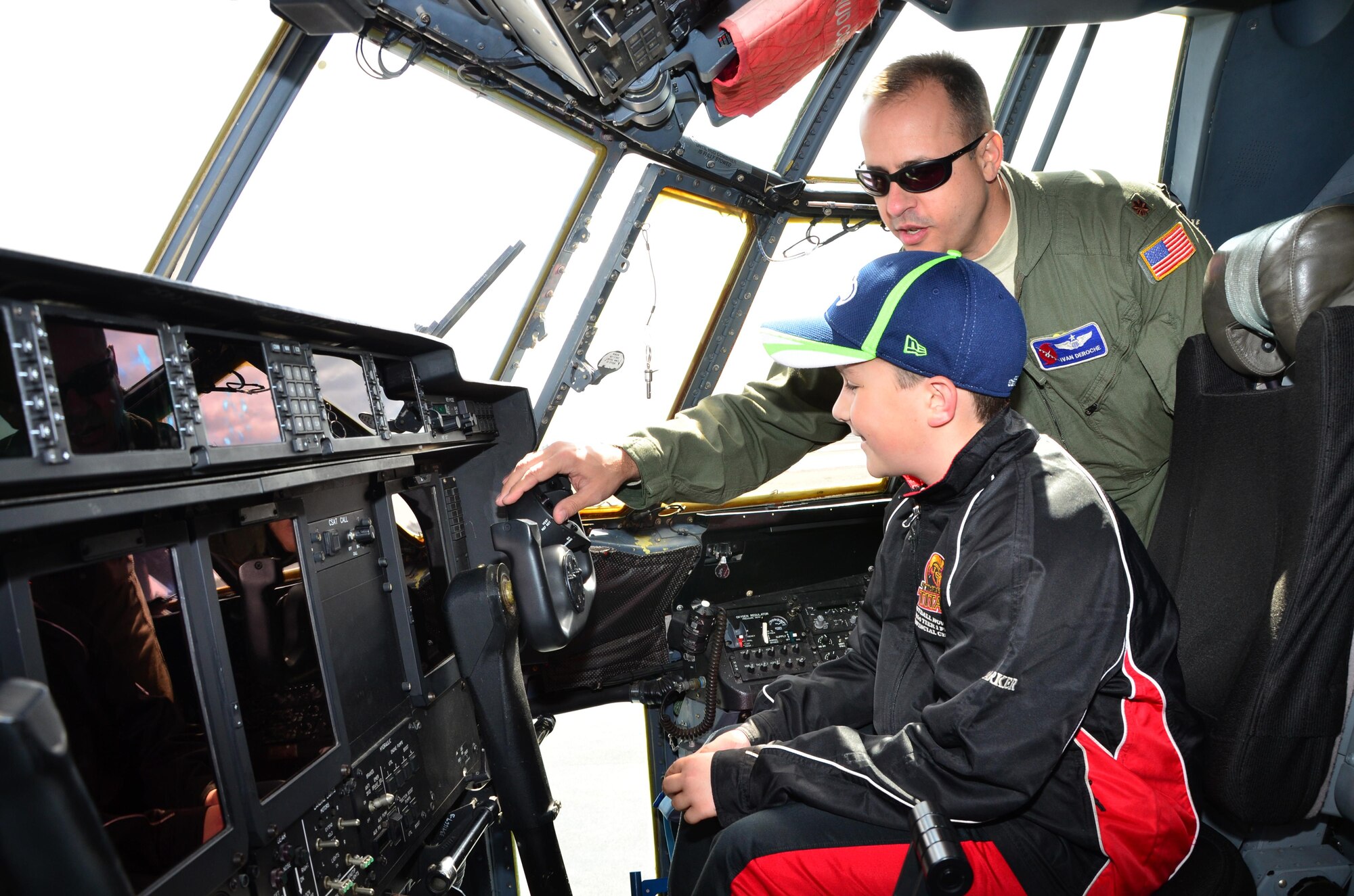 Maj. Ivan DeRoche, a pilot with the 53rd Weather Reconnaissance Squadron Hurricane Hunters, explains the flight controls to a young visitor during the Halifax, Nova Scotia stop of the 2015 Hurricane Awareness Tour May 3.
