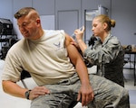 Senior Airman Leslie M. Wood of the 157th Air Refueling Wing Medical Group administers an annual seasonal flu shot to 2nd Lt. Jeffrey C. Hill during a Point Of Dispensing (POD) exercise at Pease Air National Guard Base, N.H., Nov. 6, 2010. POD exercises test roles, responsibilities and flow of people in dispensing immunizations.