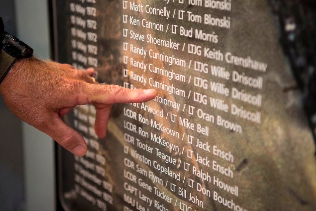 A tour guide, who was a veteran of the USS Midway, explains the significance of Lt. Randy Cunningham and Lt. j.g. Willie Driscoll during a professional military educational trip for the 11th Marine Expeditionary Unit, I Marine Expeditionary Force aboard the USS Midway Museum, San Diego,  May 6, 2015. Cunningham and Driscoll shot down their first North Vietnamese MiG on Jan. 19, 1972. On May 10, 1972, they became the first American fliers to qualify as Aces in the Vietnam War when they shot down three MiGs in a single action. In addition to becoming the first Vietnam Aces, the two became the first Team of Aces, the first to score a triple kill over Vietnam and the first U.S. all-missile Aces.