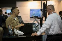 Capt James Pineiro, the Futures Directorate's Science and Technology Ground Combat Element Branch Head, talks to a visitor about the Marine Corps systems on display and the work being done within Futures Directorate with unmanned systems.