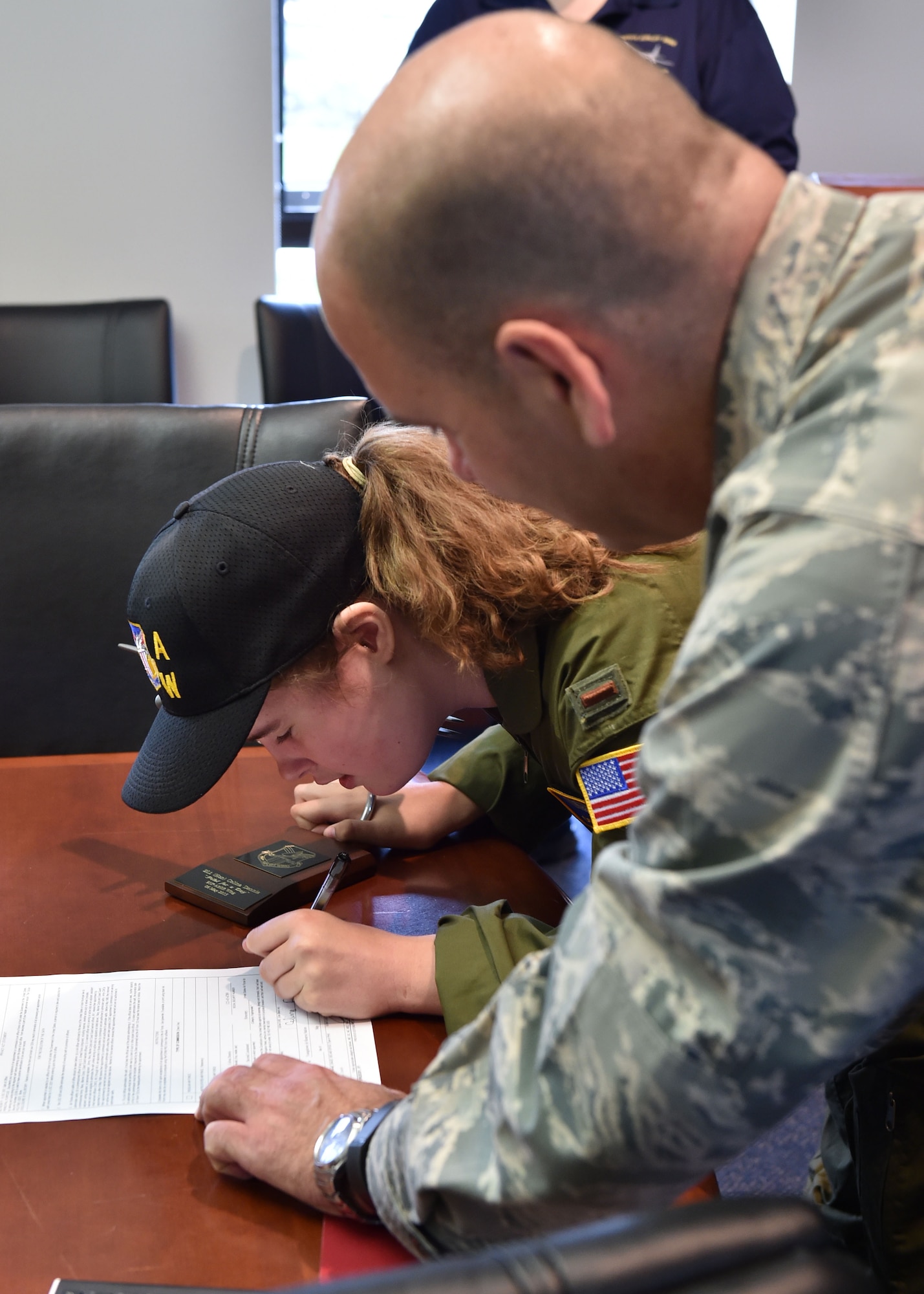 Col. James Dignan (right), 910th Airlift Wing commander, completes honorary enlistment paperwork with 12-year-old Celina Dennis of Poland, Ohio, here, May 6, 2015. Dennis was selected as the 910th Airlift Wing’s 61st Pilot for a Day, being sworn in as an honorary 2nd Lt. and treated to a day of military-themed activities here. Pilots for a Day are local children with chronic or life-threatening illnesses selected by Akron Children’s Hospital Boardman campus. (U.S. Air Force photo/Eric M. White
