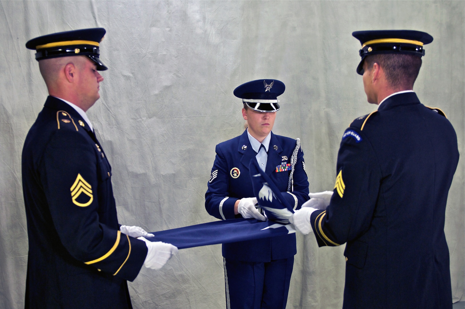 Air Force Staff Sgt. Rachel Hill of the 169th Medical Dental Group, and Army Sgt. Stephen Beasly of Company C, 1/151st Attack Recon Battalion, fold the South Carolina State flag, while Army Staff Sgt. Trevor Dean of Joint Forces Headquarters keeps the flag pulled tight. The South Carolina National Guard Army and Air Honor Guard teams have crafted a standard procedure for folding the state flag.