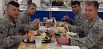 Oregon National Gurd members from the 41st Infantry Brigade Combat Team take part on the Thanksgiving festivities at the coalition dining facility at Camp Adder, Iraq, in 2009. Later, the Soldiers continued their mission as convoy security.
