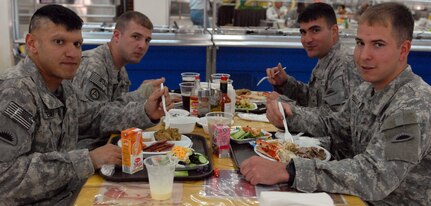 Oregon National Gurd members from the 41st Infantry Brigade Combat Team take part on the Thanksgiving festivities at the coalition dining facility at Camp Adder, Iraq, in 2009. Later, the Soldiers continued their mission as convoy security.