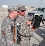 Capt. Thomas Mesloh, electronic warfare officer for the Louisiana National Guard's 2nd Squadron, 108th Cavalry Regiment, 224th Sustainment Brigade, 103rd Sustainment Command (Expeditionary), discusses the measurements on a spectrum analyzer with a convoy escort team commander at Contingency Operating Base Adder, Iraq, Oct. 16, 2010.
