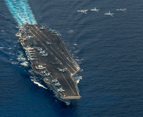SOUTH CHINA SEA (May 10, 2015) - Two F/A-18 Super Hornets and two Royal Malaysian Air Force Mig 29 Fulcrums fly in formation above the aircraft carrier USS Carl Vinson (CVN 70). The Carl Vinson Strike group is deployed to 7th Fleet area of operations supporting security and stability in the Indo-Asia-Pacific region. 