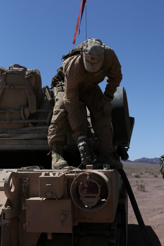 A Marine with Company A, 1st Tank Battalion, 1st Marine Division, refuels an M1A1 Abrams Main Battle Tank during Exercise Desert Scimitar aboard Marine Corps Air Ground Combat Center Twentynine Palms, Calif., April 13, 2015. The training gave the Marines the opportunity to refine and rehearse essential combat skills needed in a battlefield environment. Desert Scimitar is an annual exercise that includes elements from the I Marine Expeditionary Force. The exercise focused on conventional operations and provided realistic training that prepared Marines for overseas operations. (U.S. Marine Corps photo by Sgt. Christopher J. Moore/Released)