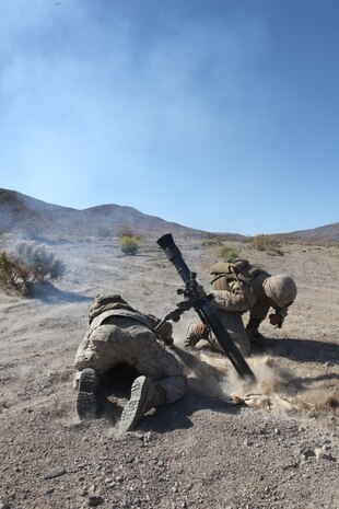 Mortarmen with Weapons Company, 3rd Battalion, 5th Marine Regiment prepare to drop a mortar round during a combined-arms raid at Army National Training Center Fort Irwin, April 11, 2015. The raid was conducted by 1st Light Armored Reconnaissance Battalion as part of exercise Desert Scimitar 2015.