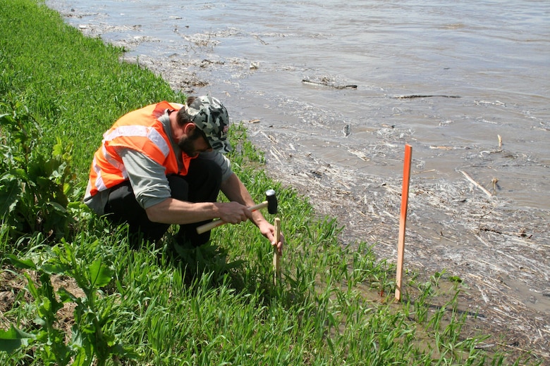 Curtis Miller from the U.S. Army Corps of Engineers, Omaha District sets a high water gage along the Salt Creek levee in Lincoln, Nebraska, following heavy rains, which fell overnight on May 6, 2015.