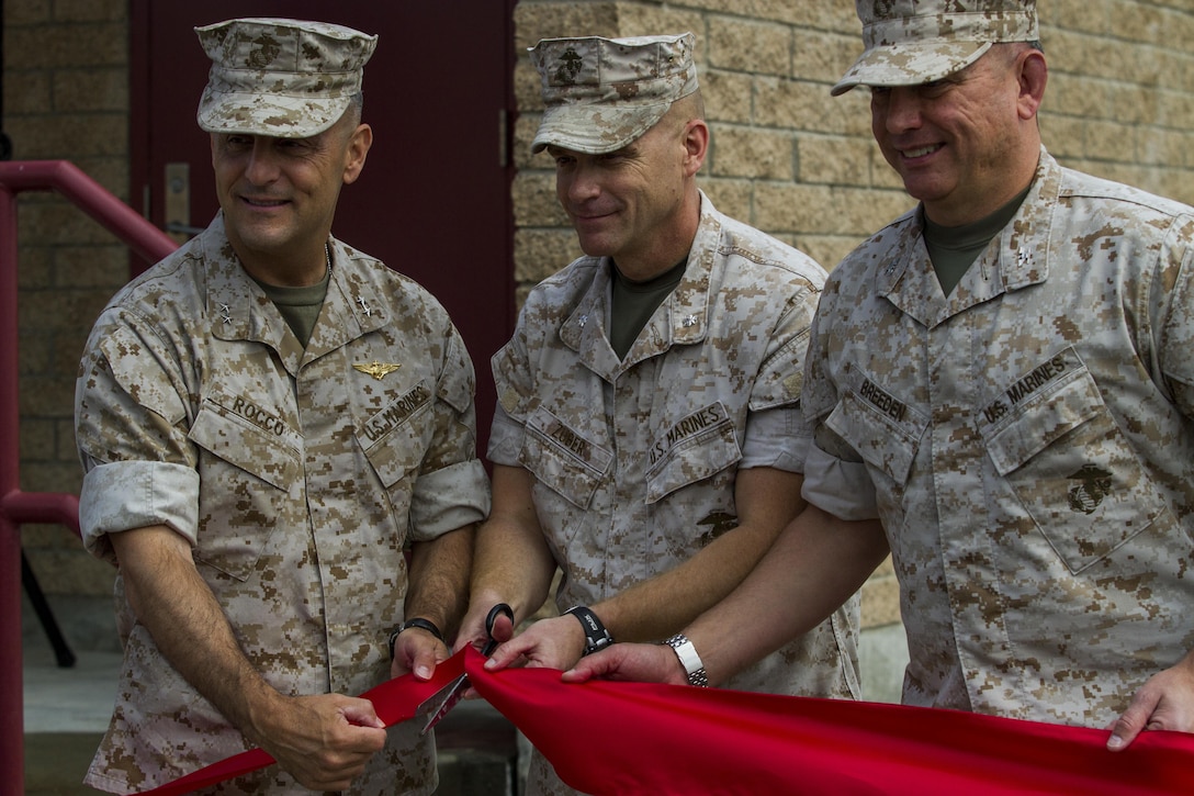 Maj. Gen. Michael Rocco, 3rd Marine Aircraft Wing commanding general, and Col. Chad Breeden, Marine Air Control Group 38, hold a ribbon while Lt. Col. Wayne Zuber, 3rd Low Altitude Air Defense Battalion commanding officer concludes a rededication ceremony with a ribbon cutting aboard Marine Corps Base Camp Pendleton, Calif., May 8. Third LAAD Bn. held the rededication ceremony for its Training and Simulation Facility, which was renovated with state-of-the-art equipment in order to provide Marines with a better training environment.