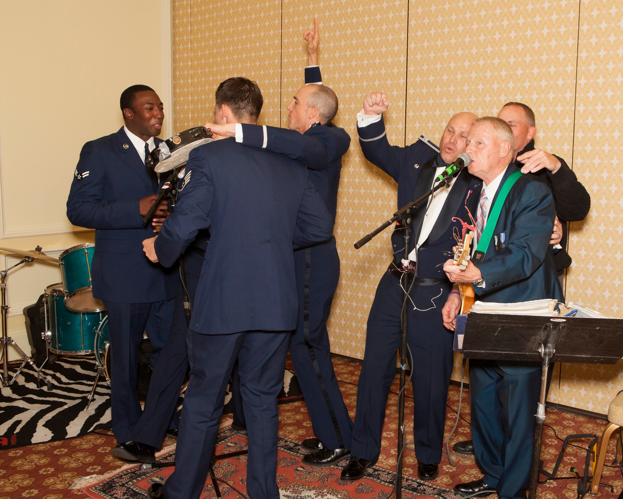 Ninetieth Missile Wing Airmen sing with the band during the dining-out on May 8, 2015. The dining-out is a formal dinner hosted by the 90th MW to provide military members and their spouses, as well as civilians, the opportunity to meet socially, and create bonds of friendships in an atmosphere which promotes fellowship, camaraderie and esprit de corps. (U.S. Air Force photo by Lan Kim)