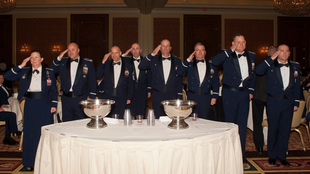 Ninetieth Missile Wing leadership salutes the head table while at the Grog during the 90th MW dining-out on May 8, 2015. The Grog is a tradition where an attendee who violates the rules of the mess is sent to drink out of two grog bowls that are filled with unappetizing ingredients. (U.S. Air Force photo by Lan Kim)