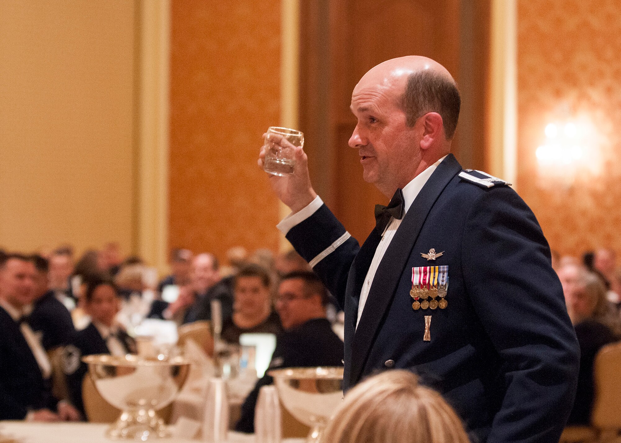 Col. Trevor Flint, 90th Maintenance Group commander, proposes a toast during the 90th Missile Wing dining-out, May 8, 2015. The dining-out is a formal dinner hosted by the 90th MW to provide military members and their spouses, as well as civilians, the opportunity to meet socially, and create bonds of friendships in an atmosphere which promotes fellowship, camaraderie and esprit de corps. (U.S. Air Force photo by Lan Kim)