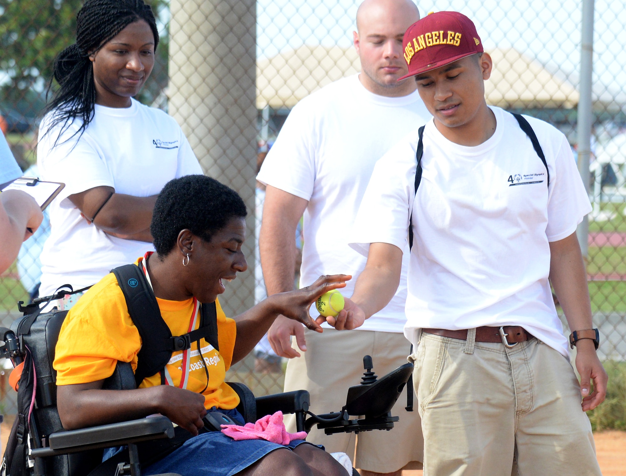 A volunteer gives an athlete a ball for the tennis ball throwing competition at the 2015 Mississippi State Special Olympics, May 9, 2015, Keesler Air Force Base, Miss. Approximately 752 athletes competed in 55 sports, ranging from aquatics to track and field events throughout the two day event. More than 2,500 Airmen and civilian volunteers and 266 coaches helped make the event a success. This year was the 29th year Keesler has hosted the event. (U.S. Air Force photo by Senior Airman Holly Mansfield)