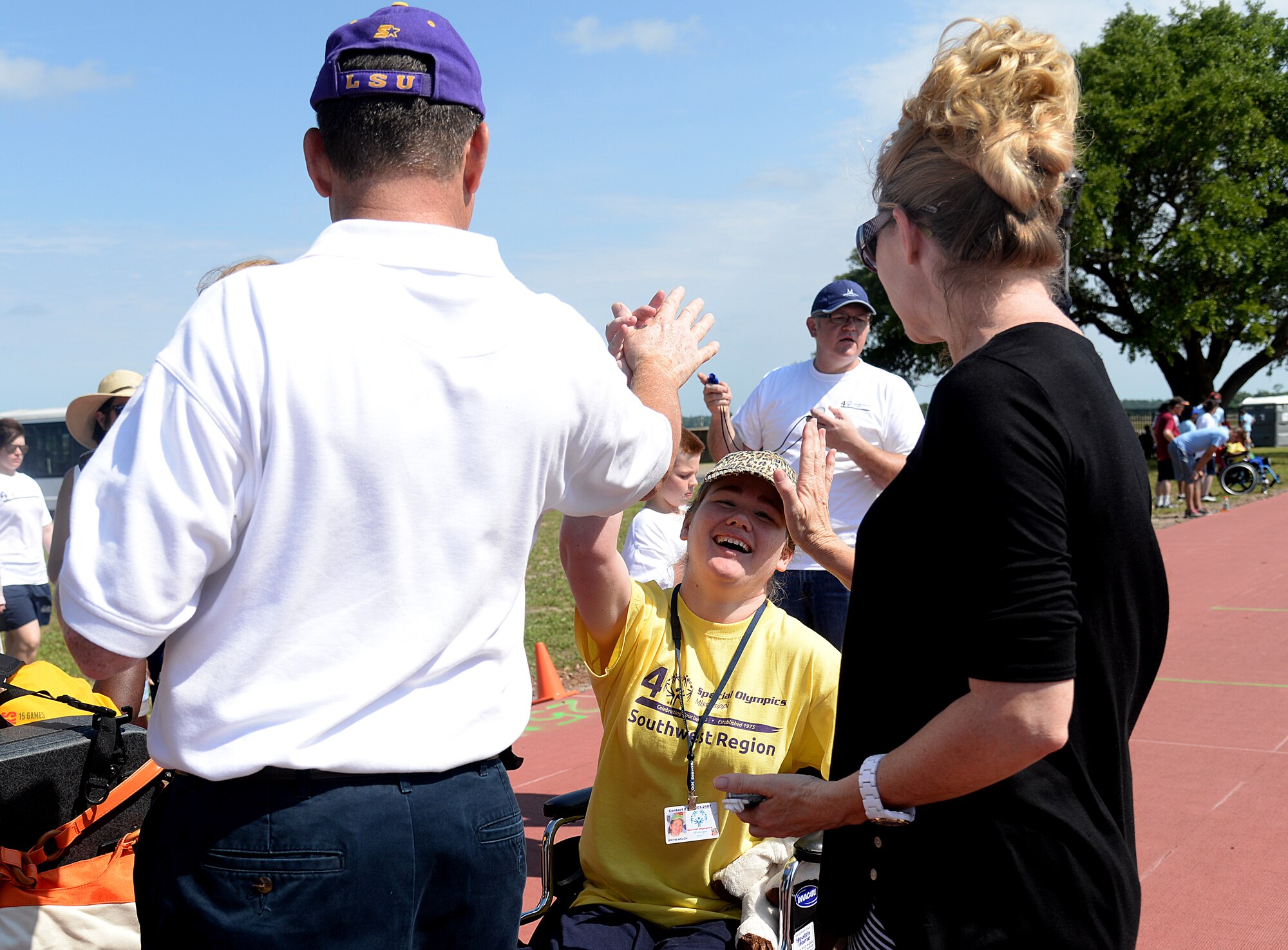 Britni Welch high fives her parents after finishing the wheelchair race at the 2015 Mississippi State Special Olympics, May 9, 2015, Keesler Air Force Base, Miss. Approximately 752 athletes competed in 55 sports, ranging from aquatics to track and field events throughout the two day event. More than 2,500 Airmen and civilian volunteers and 266 coaches helped make the event a success. This year was the 29th year Keesler has hosted the event. (U.S. Air Force photo by Senior Airman Holly Mansfield)