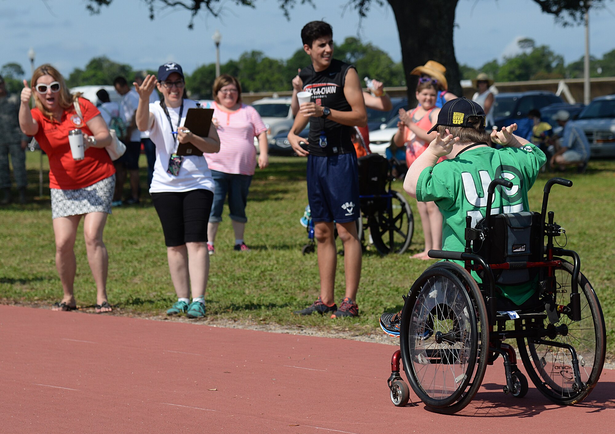 Crowd members cheer on athletes at the 2015 Mississippi State Special Olympics, May 9, 2015, Keesler Air Force Base, Miss. Approximately 752 athletes competed in 55 sports, ranging from aquatics to track and field events throughout the two day event. More than 2,500 Airmen and civilian volunteers and 266 coaches helped make the event a success. This year was the 29th year Keesler has hosted the event. (U.S. Air Force photo by Senior Airman Holly Mansfield)