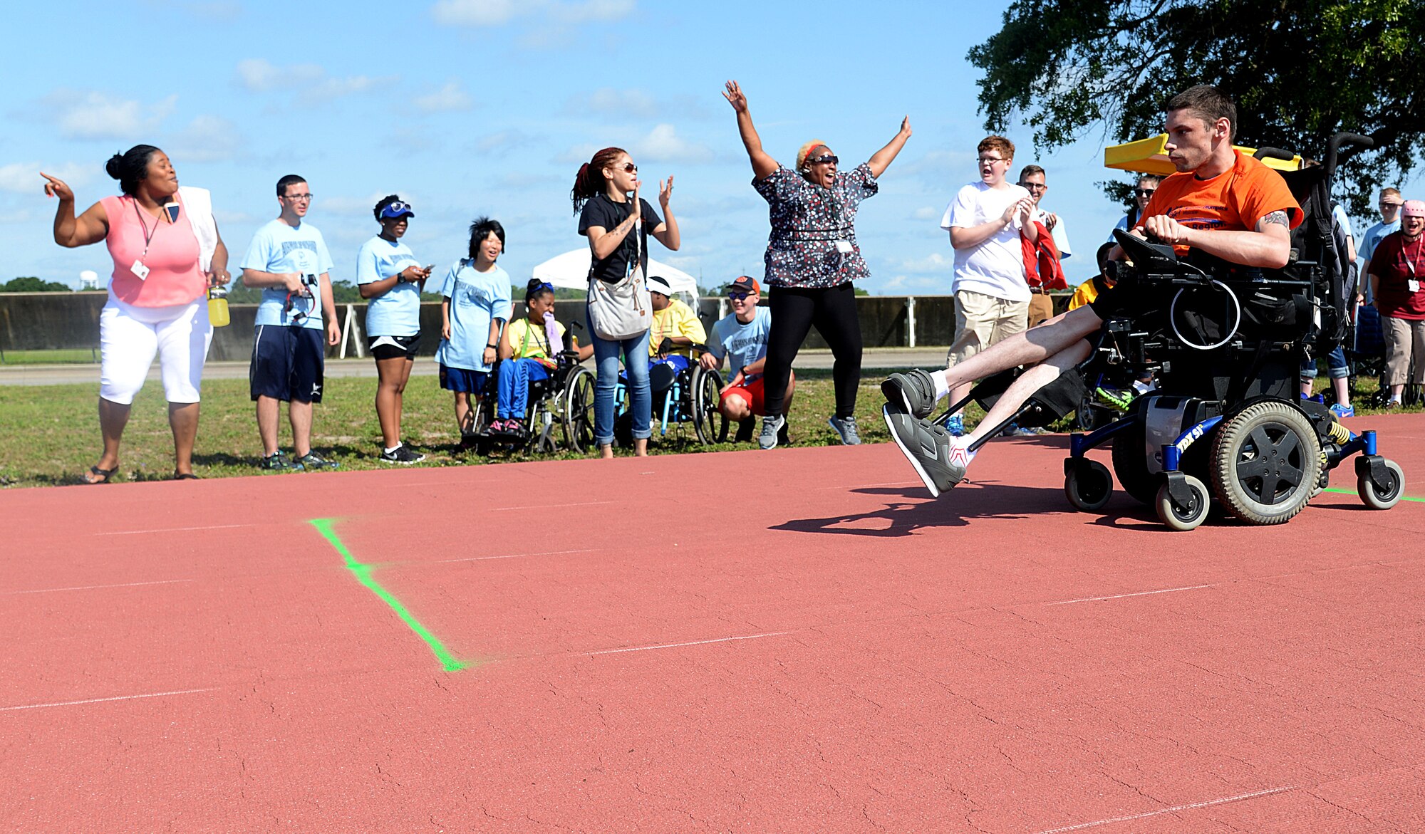 Crowd members cheer on athletes at the 2015 Mississippi State Special Olympics, May 9, 2015, Keesler Air Force Base, Miss. Approximately 752 athletes competed in 55 sports, ranging from aquatics to track and field events throughout the two day event. More than 2,500 Airmen and civilian volunteers and 266 coaches helped make the event a success. This year was the 29th year Keesler has hosted the event. (U.S. Air Force photo by Senior Airman Holly Mansfield)