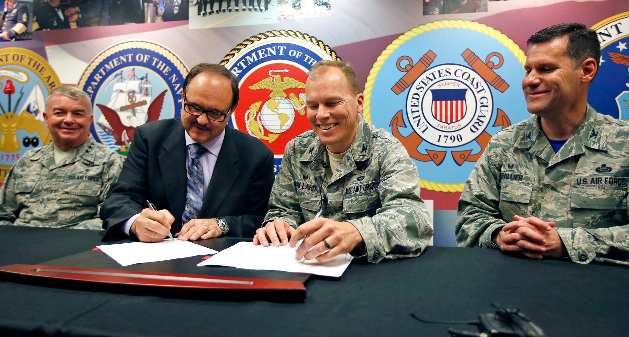 Jack Hetrick, network director for Veterans Integrated Service Network, VISN 10 (center left) and Col. Tim Ballard, 88th Medical Group commander, sign an agreement May 1 designed to improve the timeliness of medical care to veterans throughout Ohio. The signing will allow the VA to send veterans to Wright-Patterson Medical Center for inpatient or outpatient services, expanding the current relationship between VISN 10 and the Department of Defense. The men were flanked by Surgeon General of the Air Force Lt. Gen. (Dr.) Thomas Travis (far left) and Col. John Devillier, 88th Air Base Wing commander. (Cox Media Group Ohio photo by Ty Greenlees)