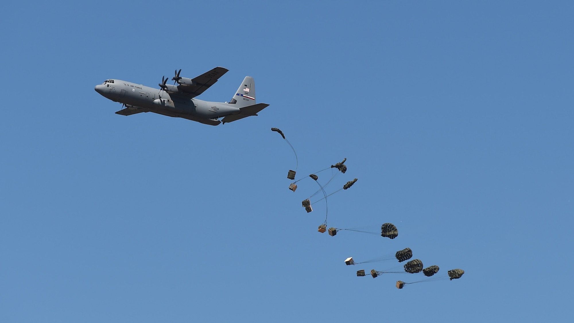 A C-130J Superhercules performs airdrops during the 2015 Dyess Big Country Airfest May 2, 2015, at Dyess Air Force Base, Texas.  During the Airshow, Dyess’ own C-130 had the opportunity to show the public various airdrops they perform, including those involving personnel, humanitarian aid supply and heavy equipment bundles.   (U.S. Air Force photo by Airman 1st Class Alexander Guerrero/Released)